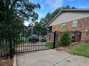 Black iron driveway gate at a brick home in Russellville, AR