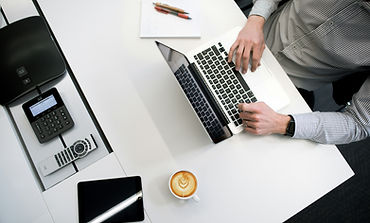 person working on desk from a laptop