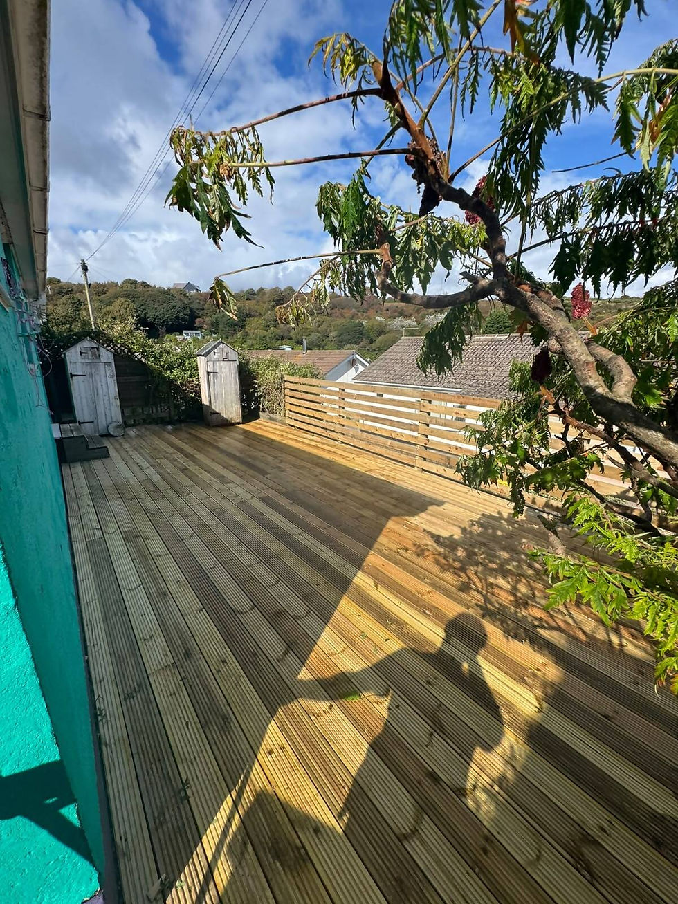 Close-up of a newly constructed wooden decking with visible support beams and surrounding greenery.