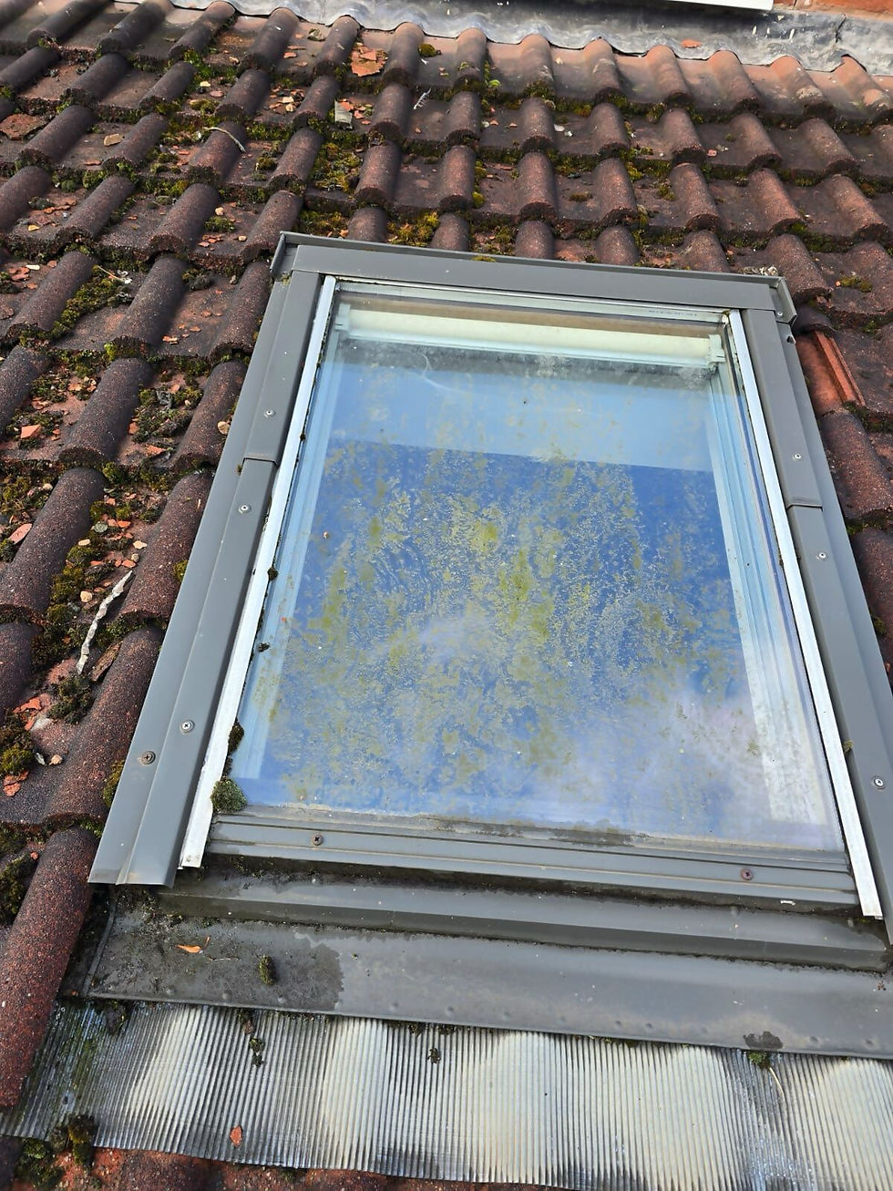 Skylight window surrounded by clean roof tiles after maintenance