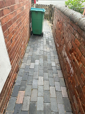 tidy paved path with green bin at the end