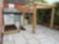 Grey stone patio with wooden pergola