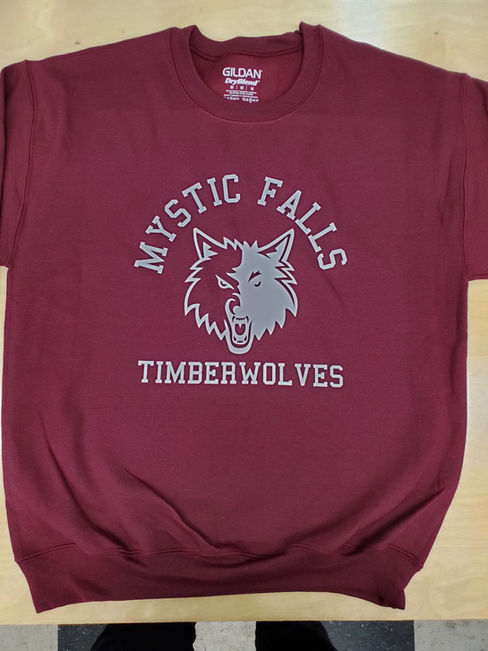 Maroon screen print sweatshirt with Mystic Falls Timberwolves wolf graphic; a custom sweatshirt showcasing bold school spirit. At Wow! Custom Tees