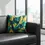 Thumbnail: Modern art cat cushion cover in petrol and gold tones styled on a dark sofa in a contemporary living room.