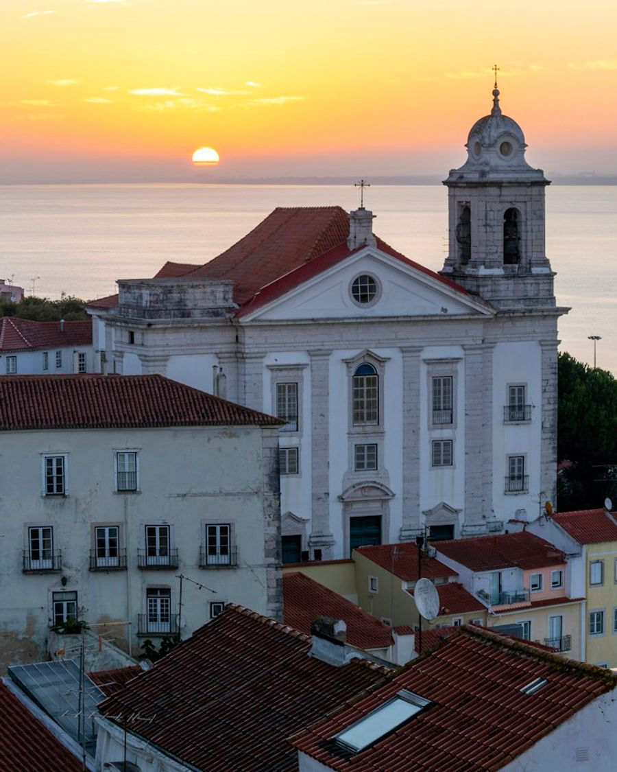 Pôr do sol sobre o Tejo visto de um miradouro de Alfama
