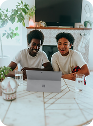 Two Black men smiling around a computer