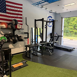 Strength training area with power racks and turf at Chardon Performance Therapy