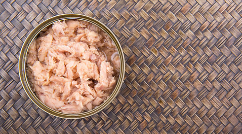 Pieces of tuna fish in a can over wicker background.jpeg