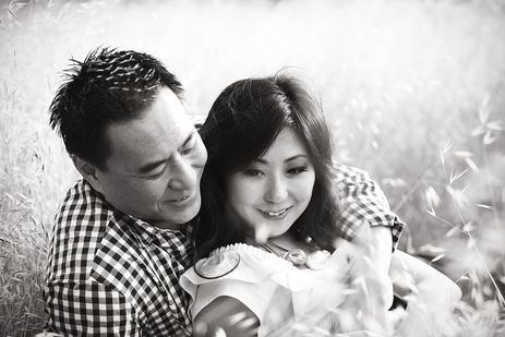 Asian couple laying in the grass