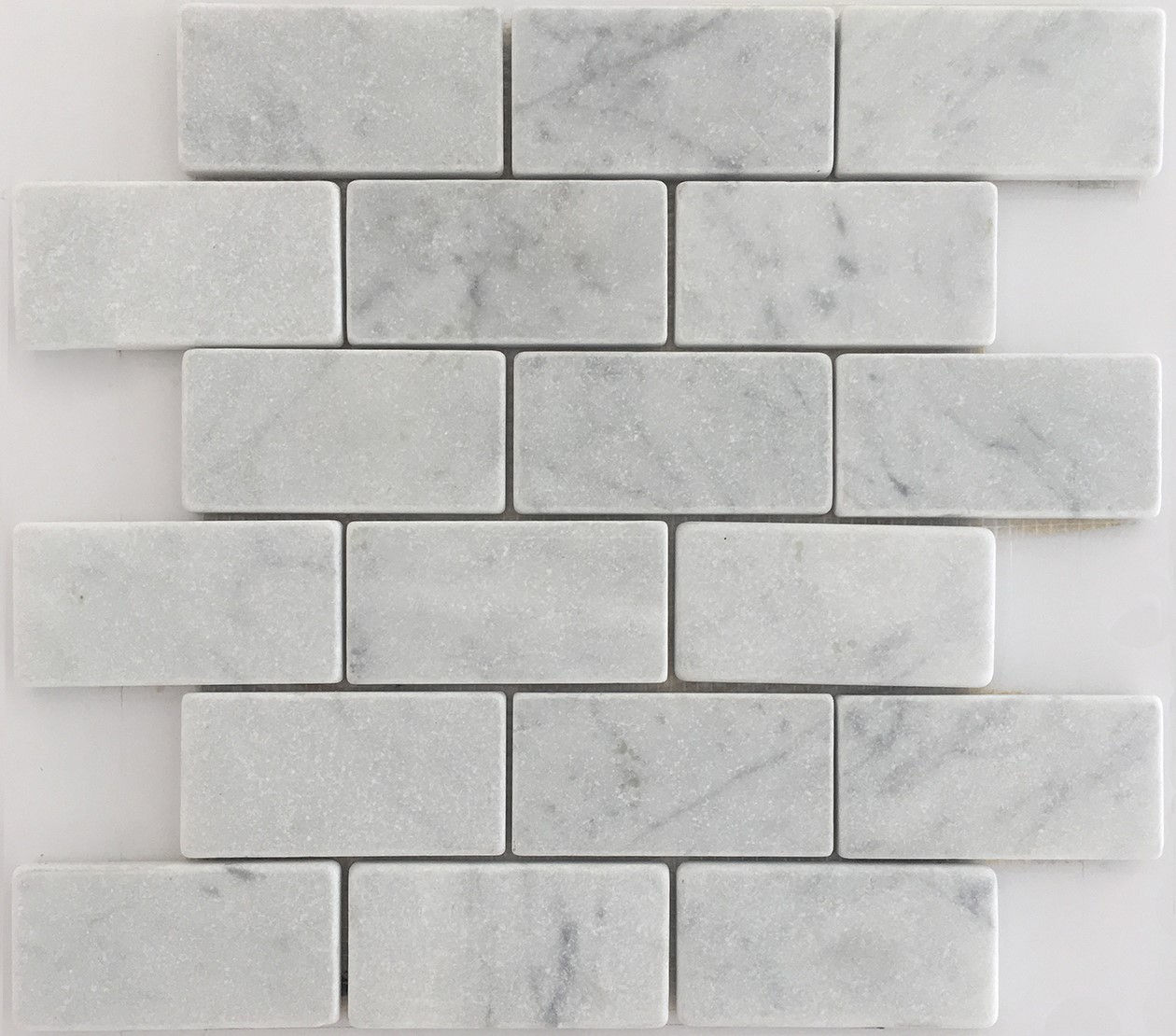 Italian marble bianco carrara in a subway tile shape with a soft tumbled finish