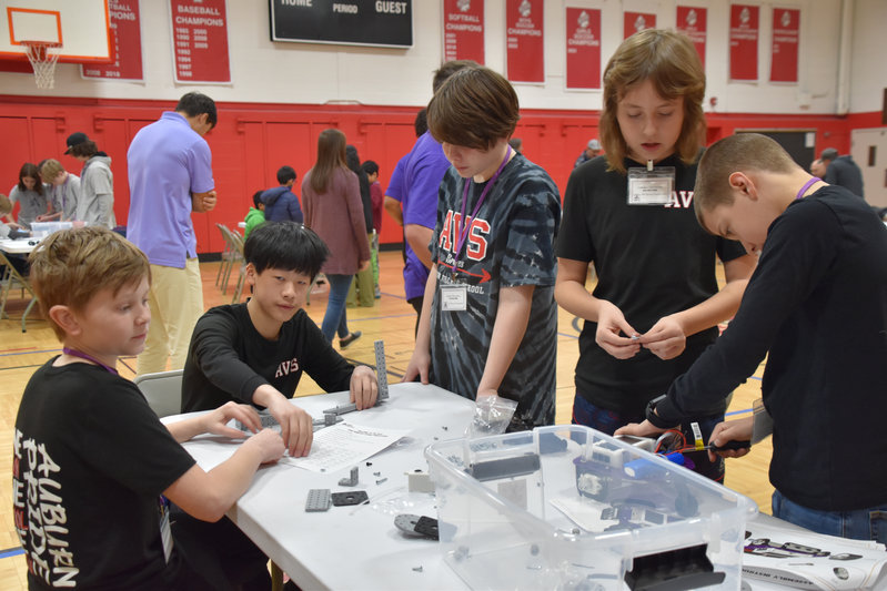 “Students assembling robots using FlexForge kit components during robotics competition