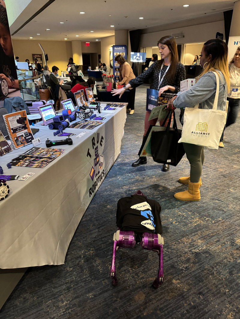 True Robotics at their table with robots, curriculum, and other items