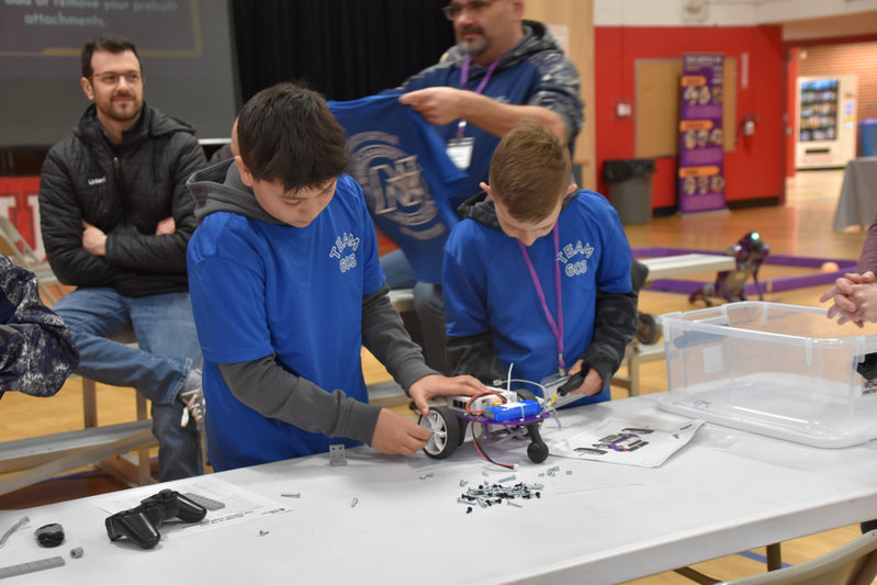 “Students assembling robots using FlexForge kit components during robotics competition