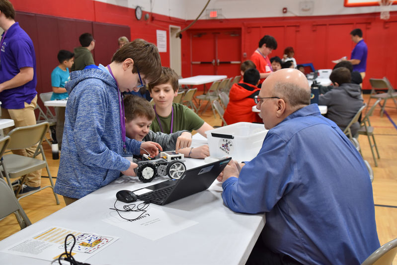 “Students assembling robots using FlexForge kit components during robotics competition