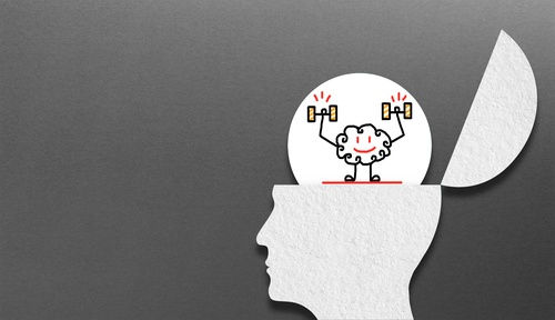 cartoon image of a head with the top hinged open and a brain emerging lifting 2 heavy weights