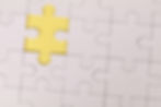 White puzzle with a yellow piece missing in the center. Light background emphasizes the gap, symbolizing incompleteness or potential.