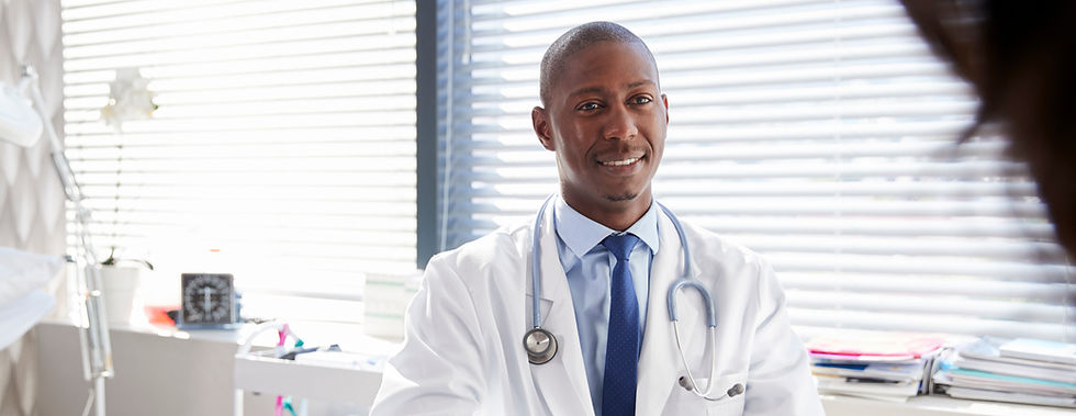 Smiling doctor in white coat with stethoscope in office setting smiling.