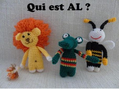 Trois figurines crochetées, lion, grenouille et lapin, sur fond beige, avec le texte Qui est AL ?