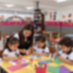 Niños de preescolar hacen manualidades en su salón con la maestra