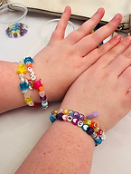 A member of our meet and makes arms showing off her rainbow coloured bead bracelets she made.