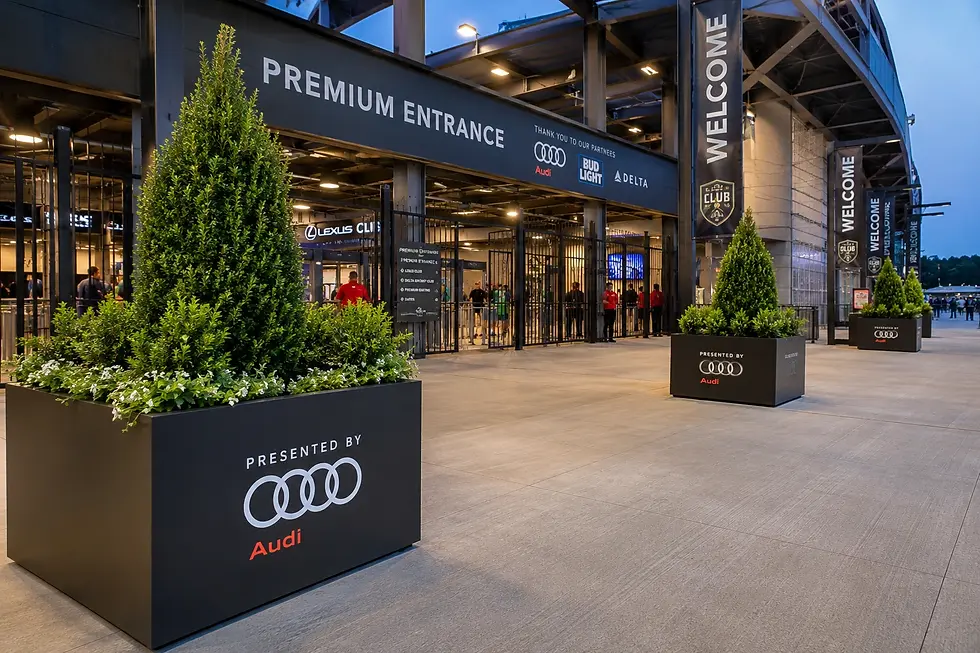 Custom sponsor-branded planters positioned at a stadium premium entrance gate