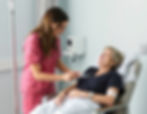 person receiving IV infusion in IV chair happy assisted by nurse.jpg