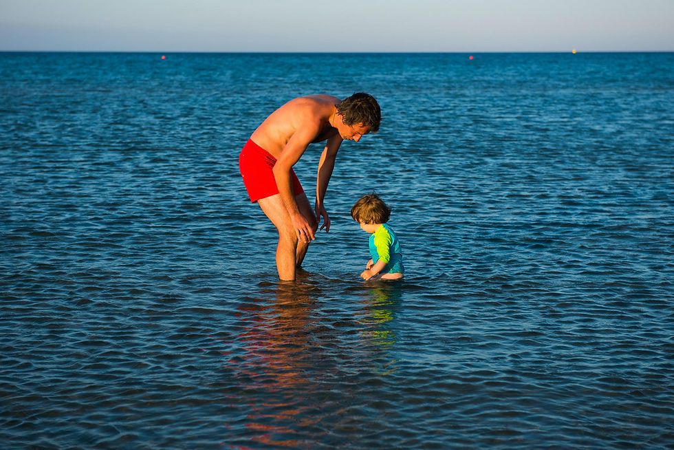 Father and daughter playing together in the sea water in summer vacation