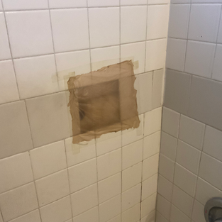 Missing tile in shower during home inspection.