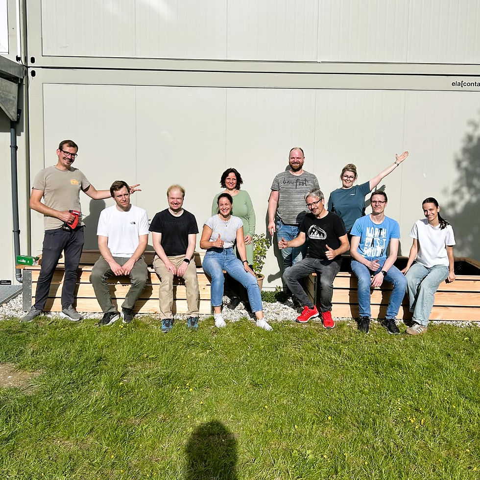 eMoSys team building raised garden beds and setting up a sign during Social Day 2026 at the Irmgard Stadler Children’s Center in Starnberg