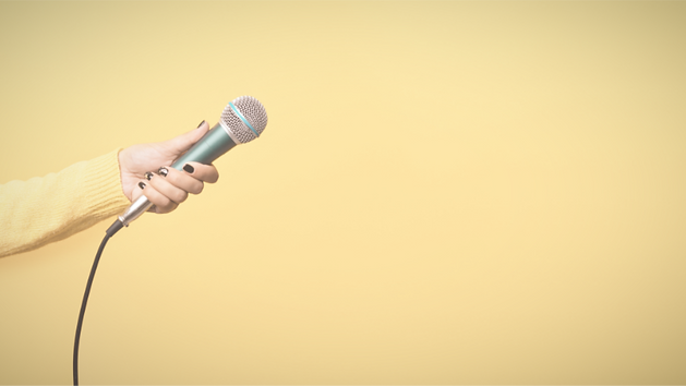 Woman with black painted nails holding a microphone