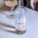 Skeptic Distillery Vodka in focus in front of a cocktail