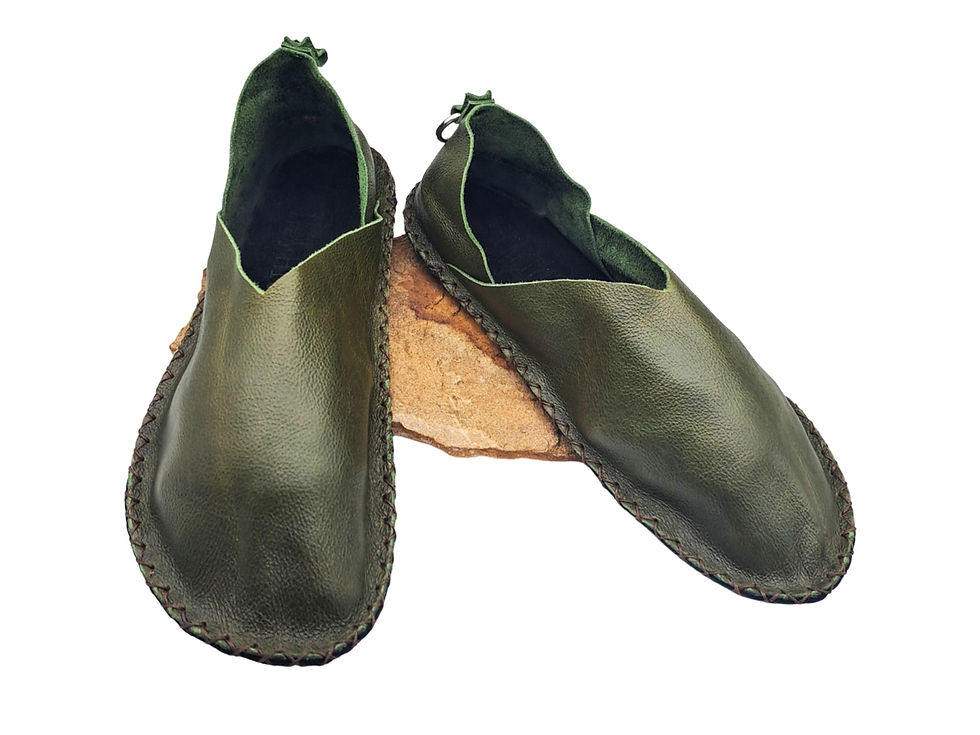 Green handmade barefoot shoes offering comfort while supporting posture, foot strength, and a natural way of moving.