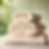 3 rolled towels stacked in a triangle, white in color with a relaxing background.png
