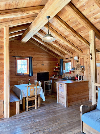 Intérieur en bois du chalet d’alpage Célestin, avec cuisine et coin repas.