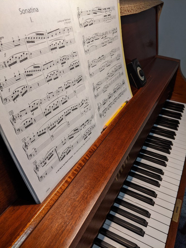 Piano with intermediate music, pencil, and metronome; Piano Practice Tips with Blossom Piano Studio
