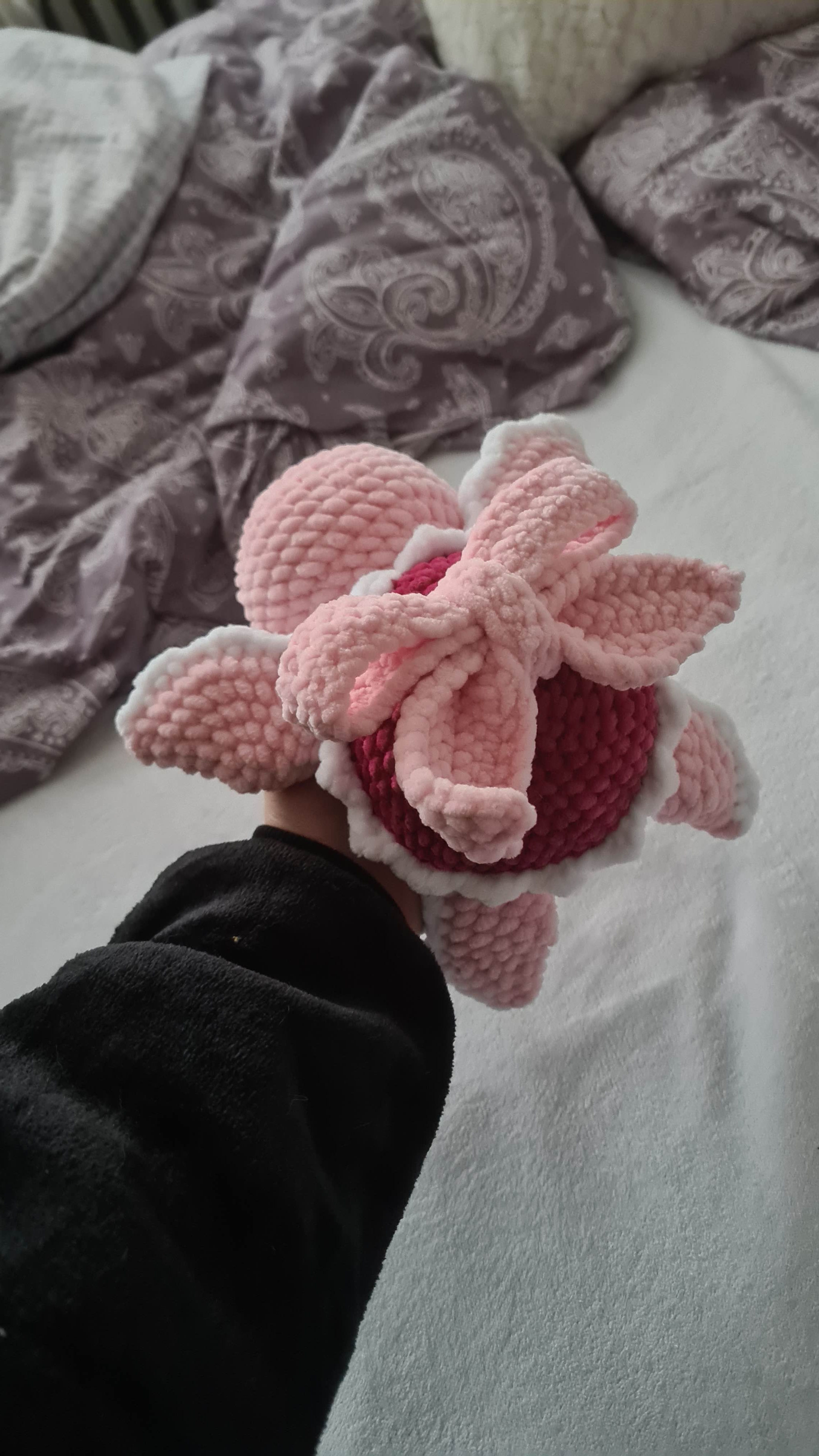 Pohled na háčkovanou růžovou valentýnskou želvičku se zdobnými okraji a velkou mašlí