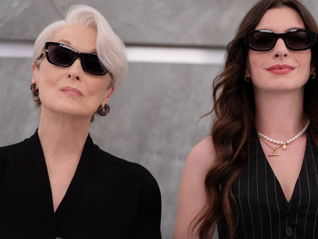 Miranda Priestly and Andy Sachs wearing black designer outfits and sunglasses in a sleek editorial-style fashion image representing ambition, leadership, and modern work culture.