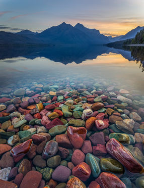 Mountain lake with clear glacier water and rainbow colored rocks