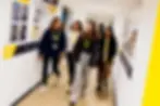 A diverse group of sixth form students walking together along the corridor of John Leggott College campus wearing comfortable, casual everyday clothing.