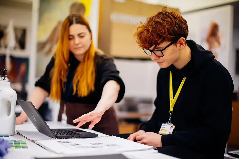 A John Leggott College student in an art lesson working at a desk with a teacher