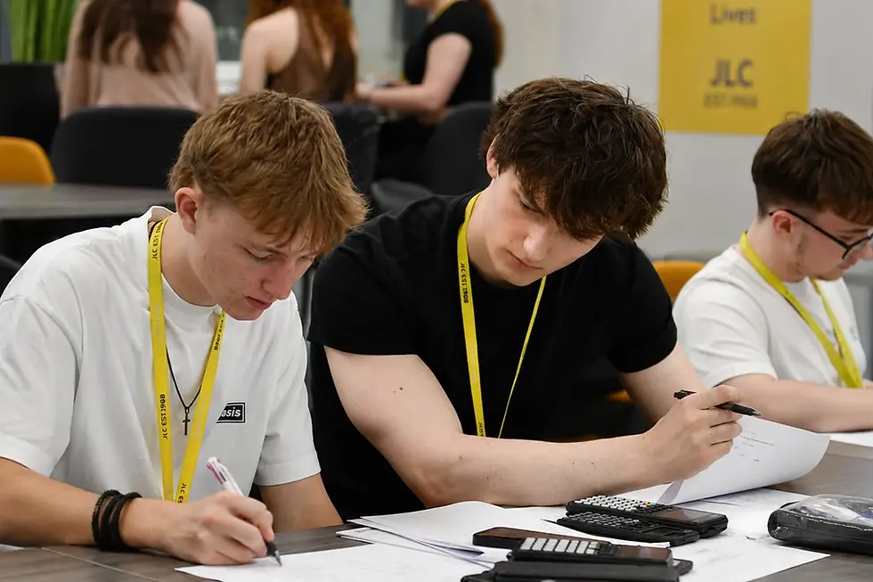 JLC students seated at tables in the Hub social space at John Leggott College, Scunthorpe, taking part in a lunchtime revision session ahead of their final exams. Students have notes and course materials in front of them.