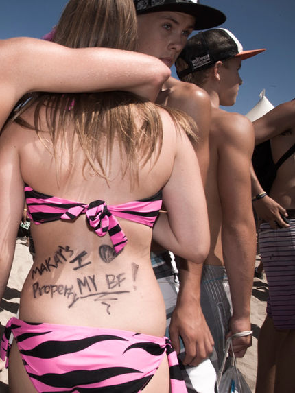 teenagers on the beach with funny writing on their backs