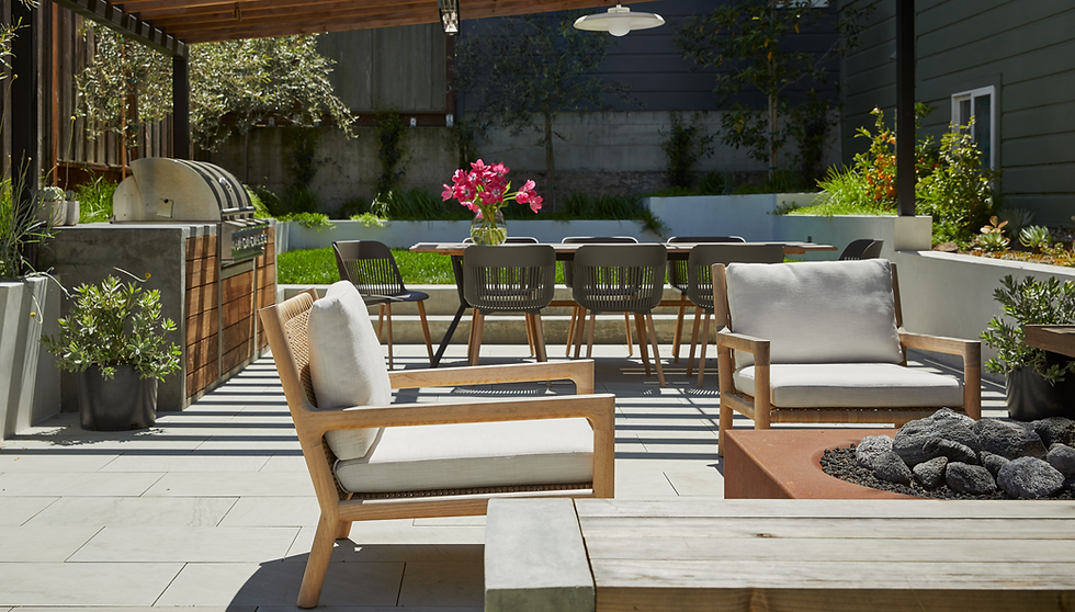 Modern outdoor patio with dining area, grill, and lounge chairs