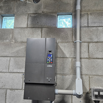 Industrial control panel mounted on a concrete block wall