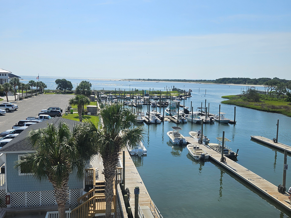 Aerial view of boats docked at a marina under a blue sky.