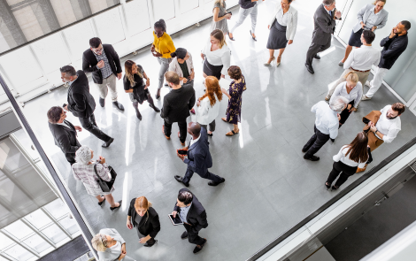Large group of business people walking together in a modern building.
