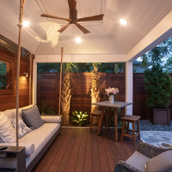 Modern covered patio with wood siding and swing sofa