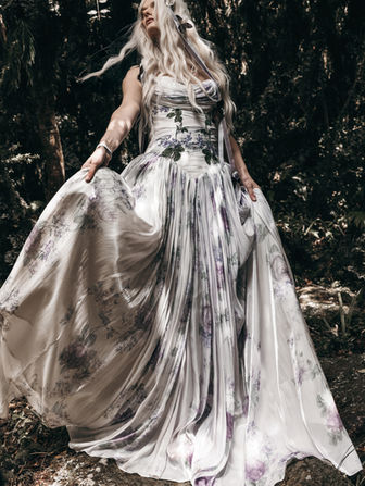 Rhea feels fluid and romantic in a way that really comes to life when you move. This Rue de Seine wedding dress is crafted in liquid organza, available in a dusty floral with soft purples and greens or a more pared-back off-white for a cleaner, more understated feel.

The corseted bodice is draped and hand-appliquéd with florals to softly contour the waist, opening into a full skirt and sweeping train that catches the light with every step. Whether you’re drawn to the color or the simplicity of ivory, this organza wedding dress feels airy, effortless, and just a little bit magical.