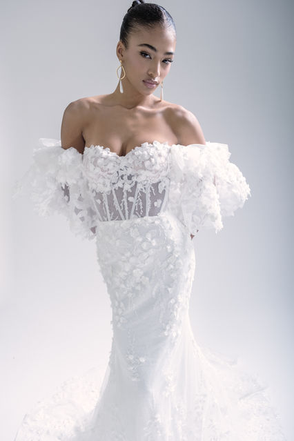 Alba by Gabrielle is where classic romance meets high fashion. ✨ This floral lace stunner features a strapless sweetheart neckline and a corset bodice, sculpting a dreamy, fitted silhouette. But it’s the details that make her unforgettable—dimensional flowers, pearls, beading, and sequins add texture, sparkle, and all the drama. And for the bride who loves a transformational moment, the voluminous off-the-shoulder sleeves give you two looks in one. Timeless, romantic, and totally runway-worthy.