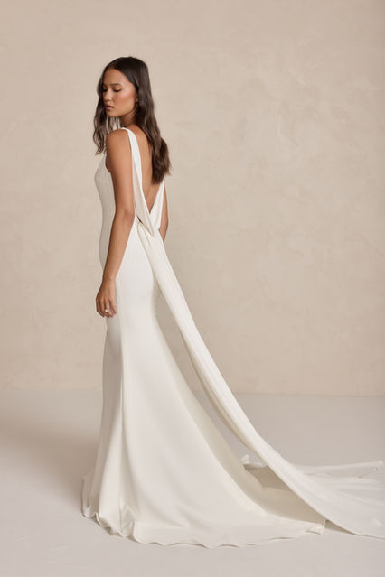 Harry's dreamy, plunging, draped back, statement detachable train and figure-hugging silhouette are a combination made in heaven. Perfect for the confident and classically beautiful bride, Harry offers the diversity of two effortlessly contrasting looks on your big day. Add a touch of drama wearing Harry's detachable, delicate train to float down the aisle and remove her train to reveal a sexy, sleek pattern with crepe buttons framing your curves to dance the night away.  Made from our signature, luxurious French Crepe, Harry will have all eyes on you.  